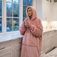 Woman wearing The Original wearable blanket in blush holding a mug in a kitchen setting