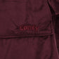 Close-up detail of The Original wearable blanket in burgundy showing Velveluxe™ fabric and embroidered logo