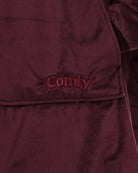Close-up detail of The Original wearable blanket in burgundy showing Velveluxe™ fabric and embroidered logo