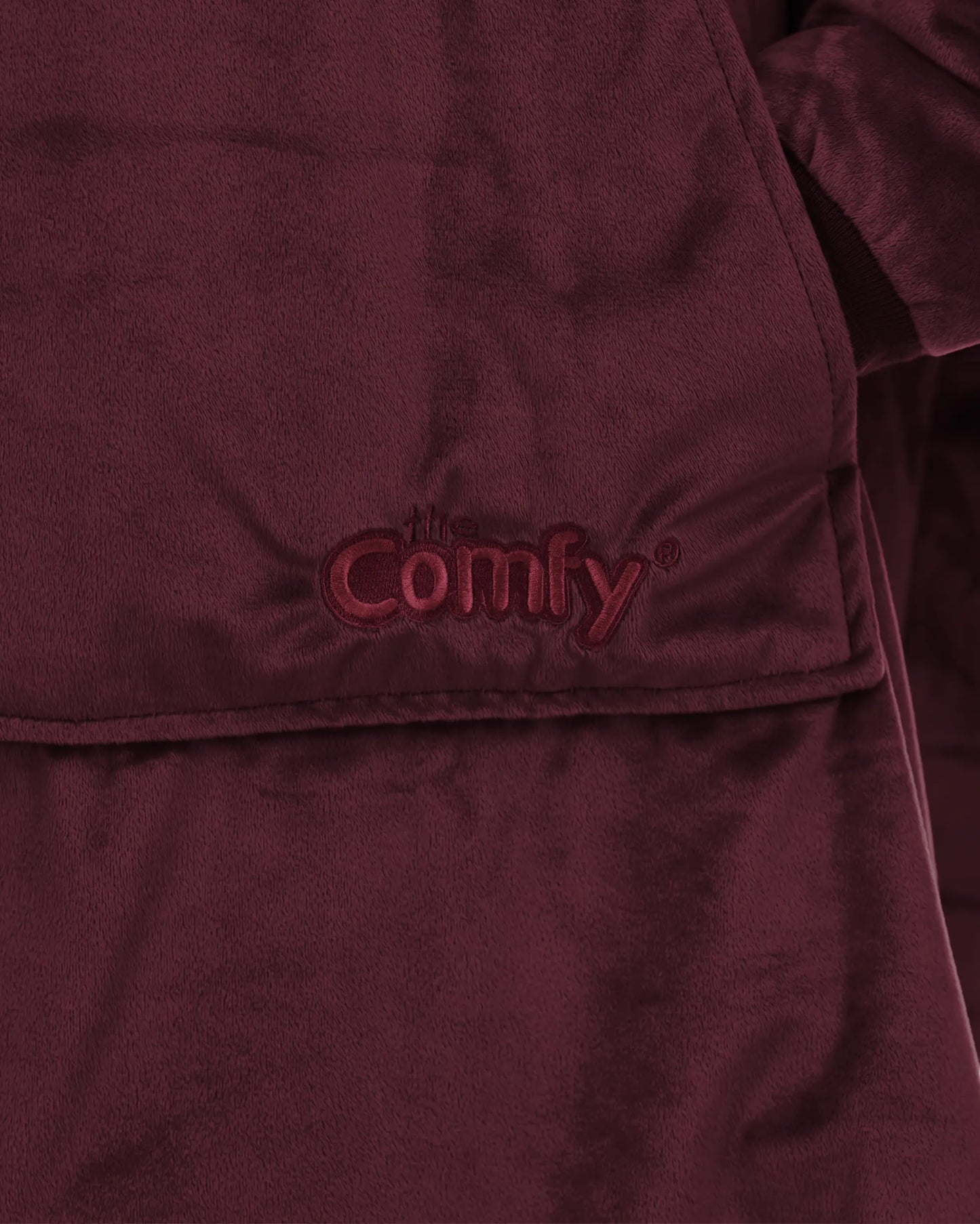 Close-up detail of The Original wearable blanket in burgundy showing Velveluxe™ fabric and embroidered logo