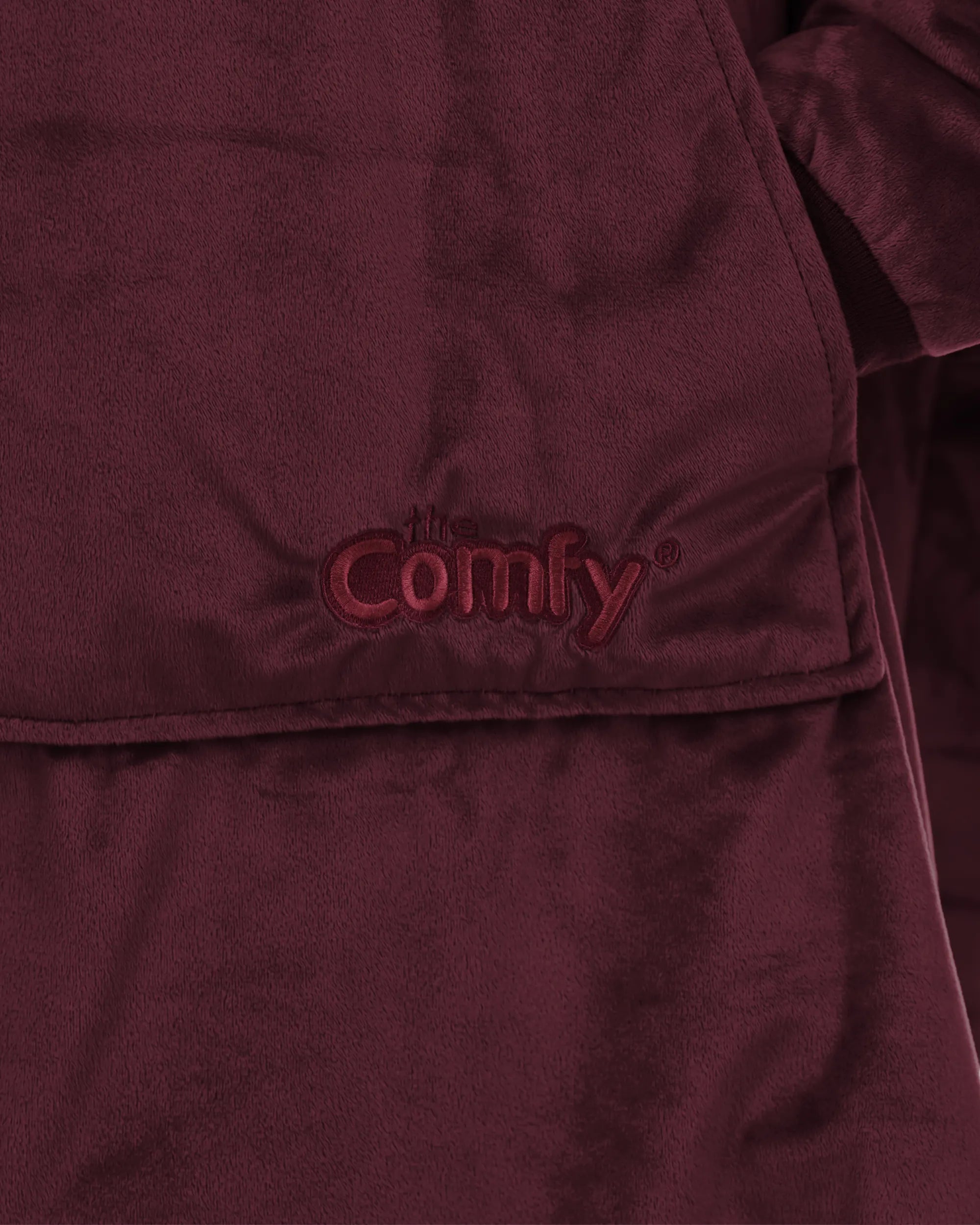 Close-up detail of The Original wearable blanket in burgundy showing Velveluxe™ fabric and embroidered logo