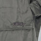 Close-up detail of The Original wearable blanket in charcoal showing Velveluxe™ fabric and embroidered logo