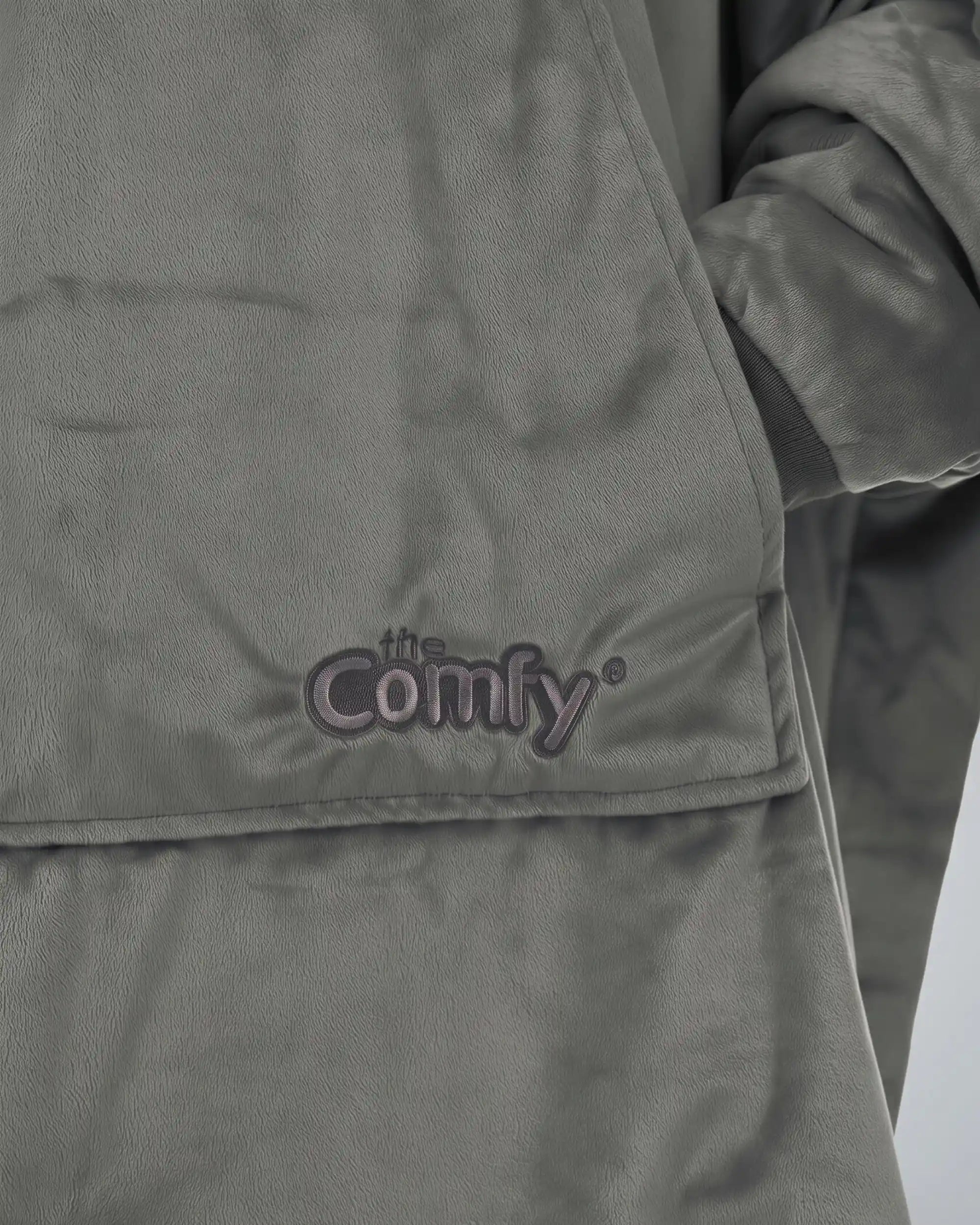 Close-up detail of The Original wearable blanket in charcoal showing Velveluxe™ fabric and embroidered logo