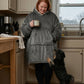 Woman wearing The Original wearable blanket in charcoal holding a mug in a kitchen with a dog nearby