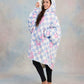 Side-angle lifestyle shot of The Original in Flower Checkered, highlighting the roomy hood, oversized fit, and ultra-soft Velveluxe™ exterior with all-over floral checkerboard print.