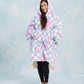 Full-body image of The Original in Flower Checkered with arms extended to demonstrate the signature oversized wearable blanket design, plush CloudSherpa™ lining, and all-day comfort coverage.