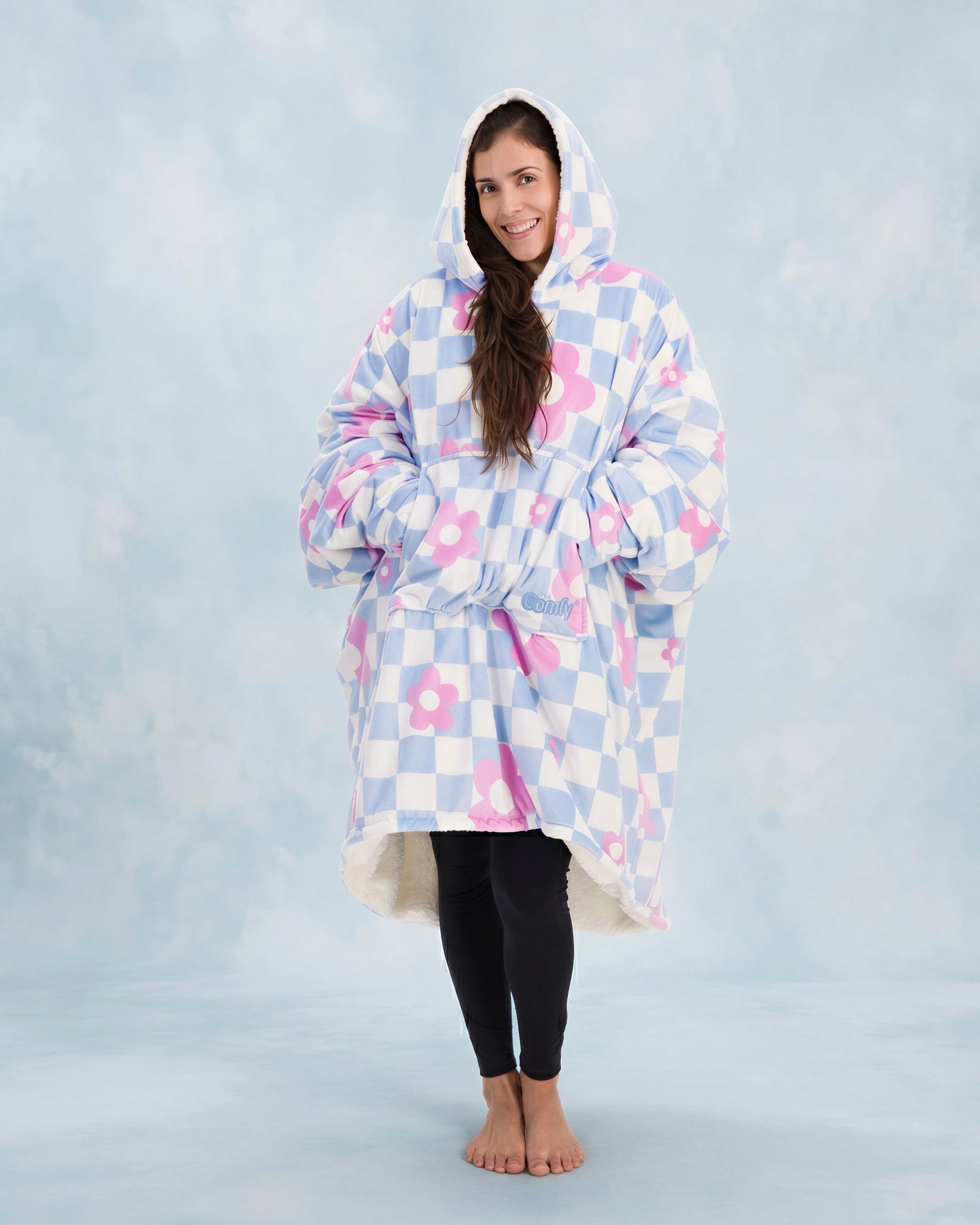 Full-body image of The Original in Flower Checkered with arms extended to demonstrate the signature oversized wearable blanket design, plush CloudSherpa™ lining, and all-day comfort coverage.