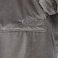 Close-up detail of The Original wearable blanket in gray showing Velveluxe™ fabric and embroidered logo