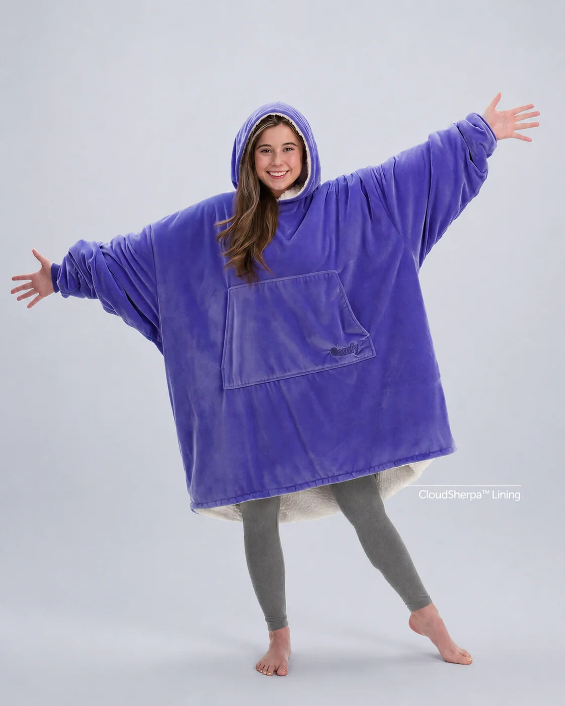 Model wearing The Original in Very Perri Purple with arms outstretched, showcasing the oversized wearable blanket silhouette, kangaroo pocket, and signature CloudSherpa™ lining for maximum comfort and coverage.