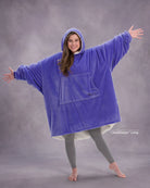 Model wearing The Original in Very Perri Purple with arms outstretched, showcasing the oversized wearable blanket silhouette, kangaroo pocket, and signature CloudSherpa™ lining for maximum comfort and coverage.