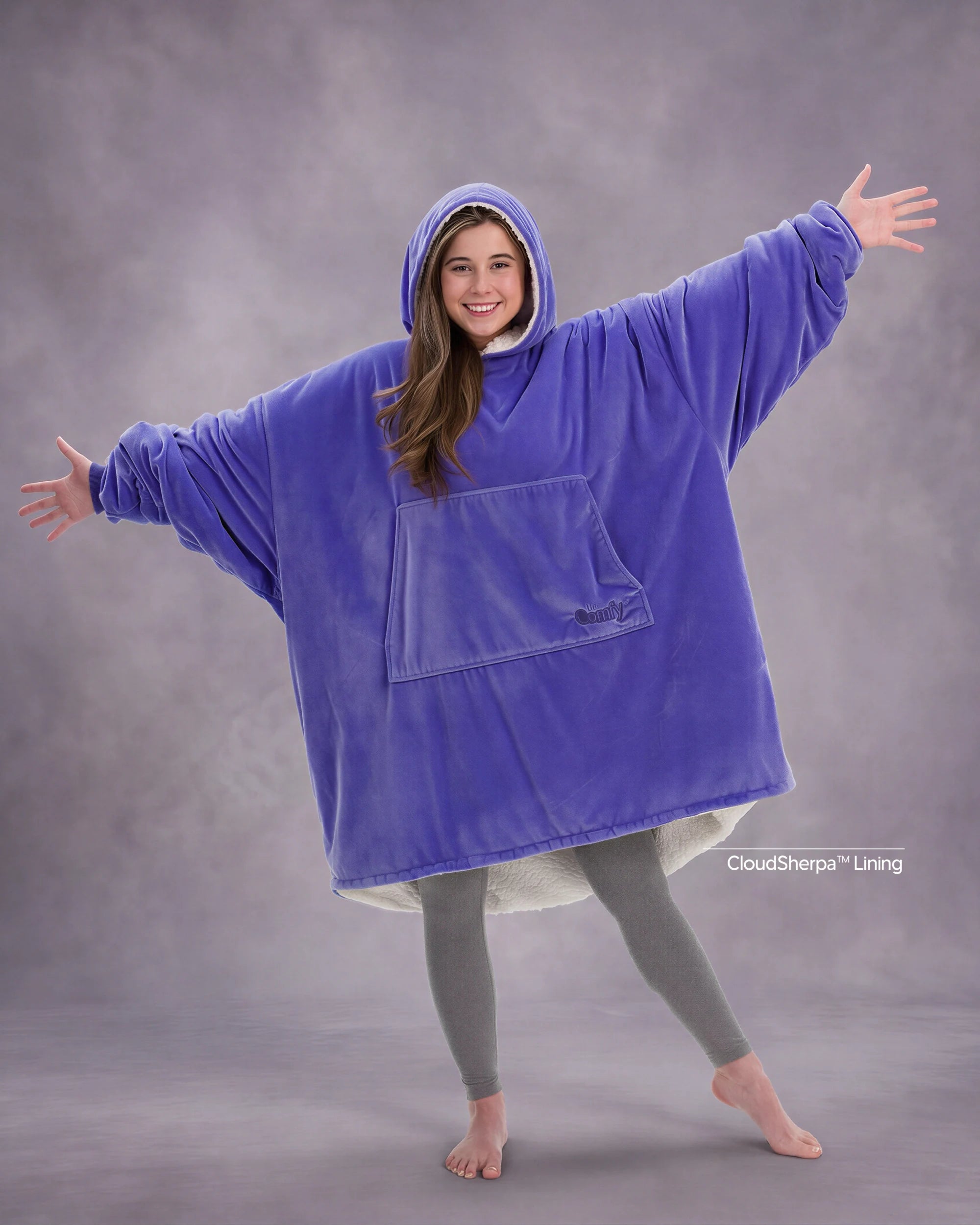 Model wearing The Original in Very Perri Purple with arms outstretched, showcasing the oversized wearable blanket silhouette, kangaroo pocket, and signature CloudSherpa™ lining for maximum comfort and coverage.