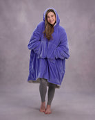 Front-facing lifestyle image of a model wrapped in The Original in Very Perri Purple, emphasizing the oversized fit, plush CloudSherpa™ lining, and cozy hands-in-pocket comfort.