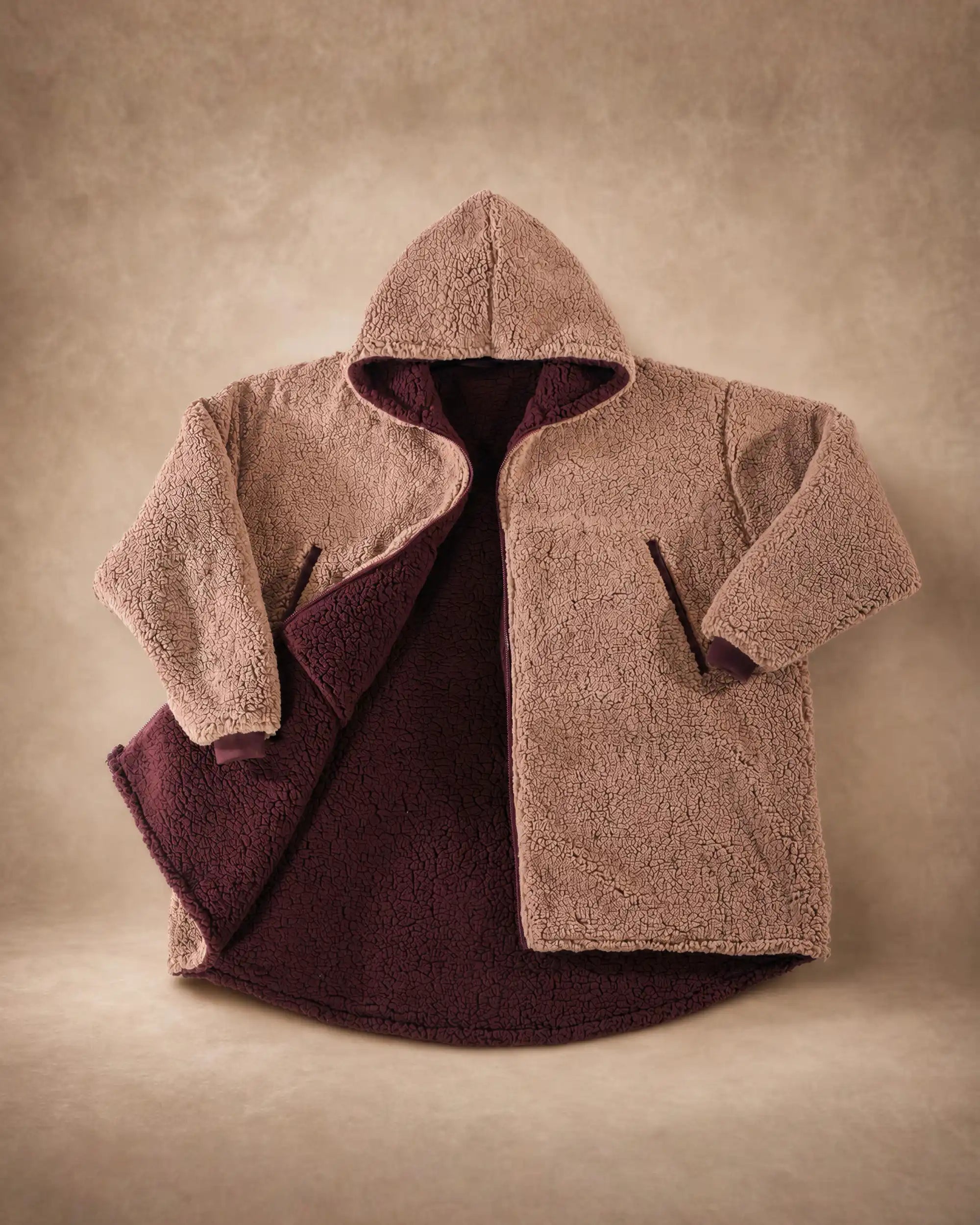 Product flat lay of the Teddy Bear Full-Zip in Camel, highlighting the all-over CloudSherpa™ texture, hood, full-length zipper, and reversible construction.
