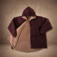 Product flat lay of the Teddy Bear Full-Zip in Chocolate, displaying the reversible CloudSherpa™ interior, oversized hood, and full-zip design.