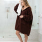 Woman wearing the Teddy Bear Full-Zip in Chocolate after a shower, highlighting warmth, comfort, and the easy on/off convenience of the full-length zipper.