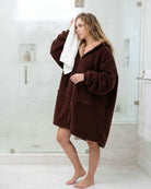 Woman wearing the Teddy Bear Full-Zip in Chocolate after a shower, highlighting warmth, comfort, and the easy on/off convenience of the full-length zipper.