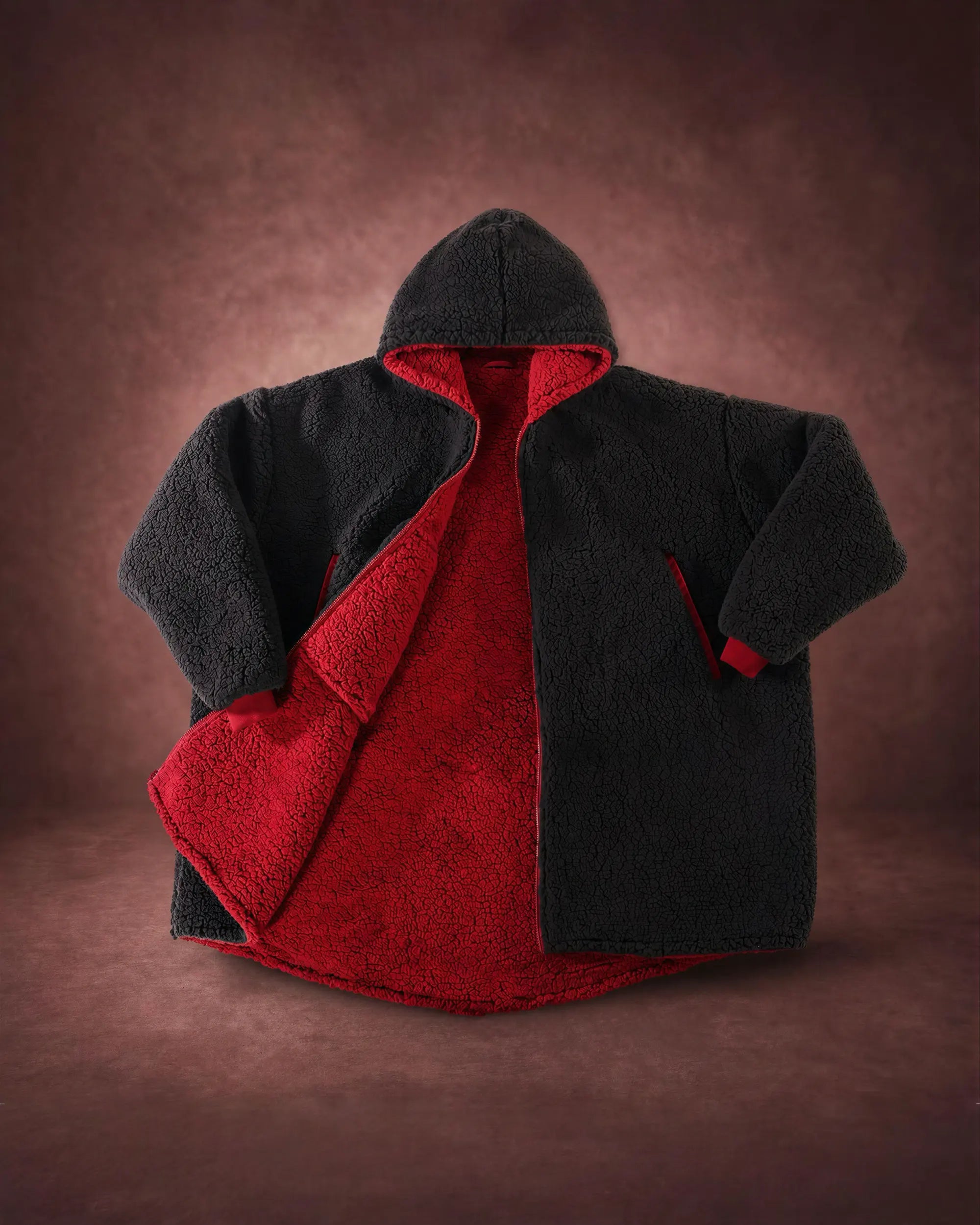 Product flat lay of the Teddy Bear Full-Zip in Black, featuring all-over CloudSherpa™, a full-length zipper, oversized hood, and reversible construction.