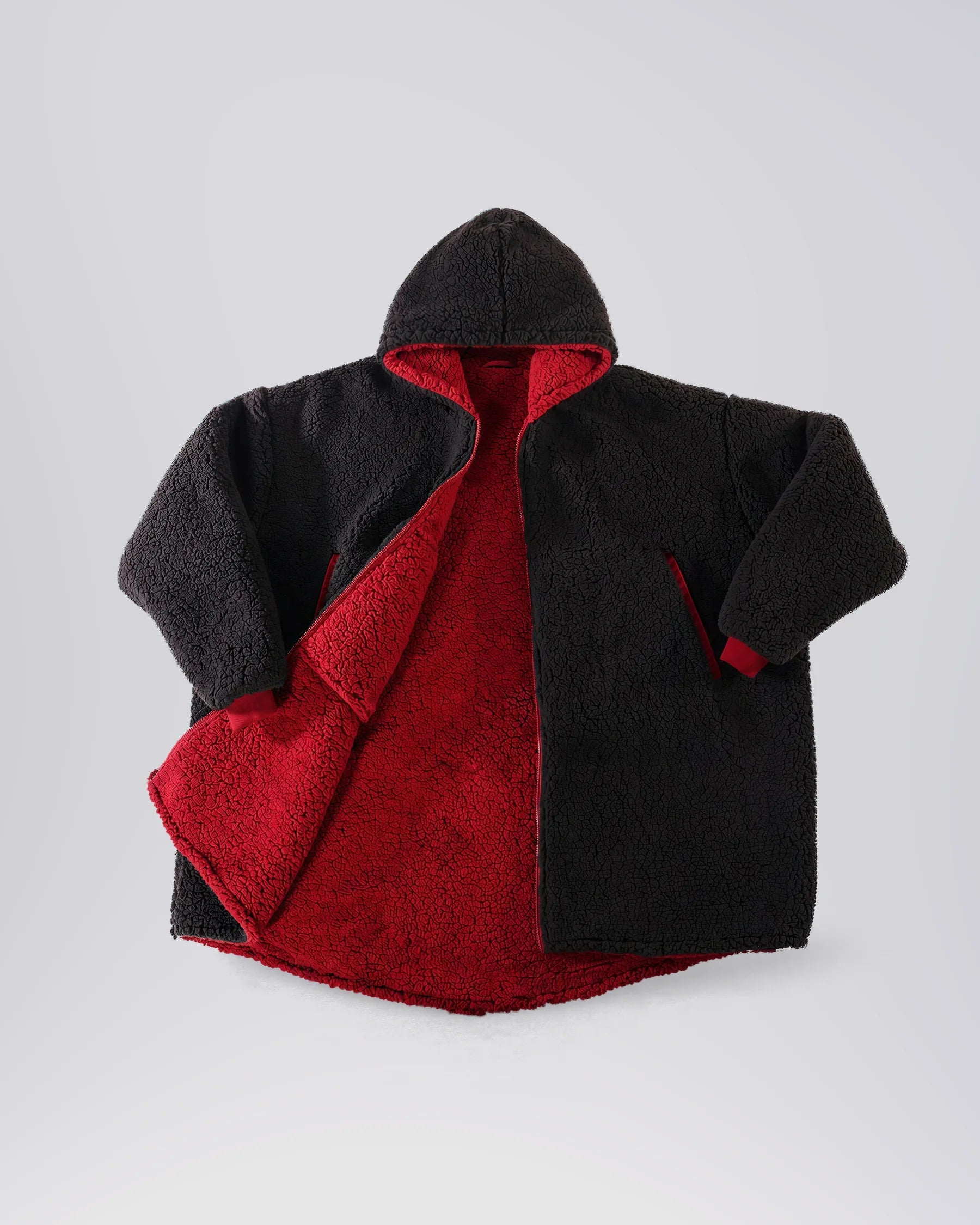 Product flat lay of the Teddy Bear Full-Zip in Black, featuring all-over CloudSherpa™, a full-length zipper, oversized hood, and reversible construction.
