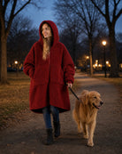 Woman wearing the Teddy Bear Full-Zip in Crimson while walking her dog outdoors, demonstrating warmth and comfort for chilly morning and evening walks.
