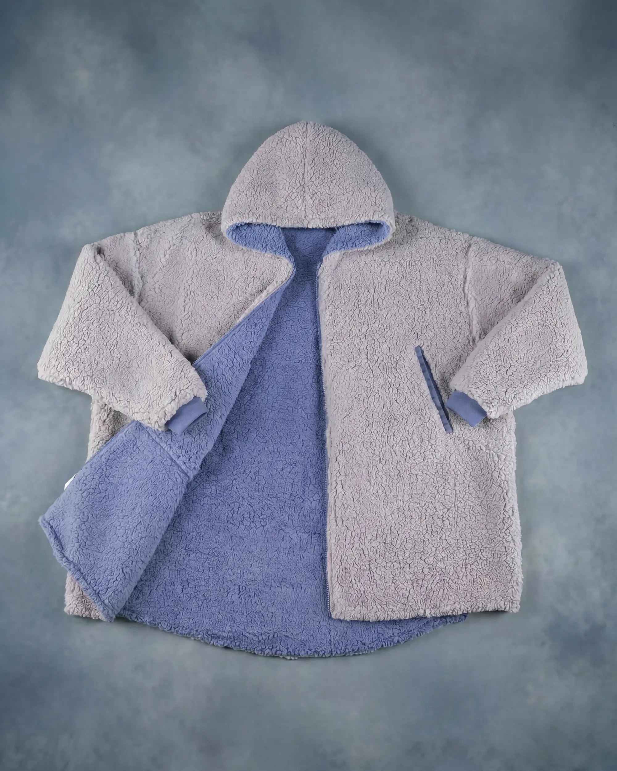 Product flat lay of the Teddy Bear Full-Zip in Light Gray, showcasing the plush CloudSherpa™ texture, oversized hood, and full-zip construction.