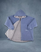 Product flat lay of the Teddy Bear Full-Zip in Denim, featuring reversible double-layer CloudSherpa™, an oversized hood, and full-length zipper.