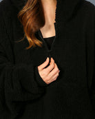 Close-up of The Teddy Bear Quarter-Zip wearable blanket in black highlighting quarter-zip neckline and plush CloudSherpa™ fabric