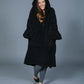 Front view of The Teddy Bear Quarter-Zip wearable blanket in black with hood up showing relaxed silhouette and cozy coverage