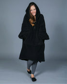 Front view of The Teddy Bear Quarter-Zip wearable blanket in black with hood up showing relaxed silhouette and cozy coverage