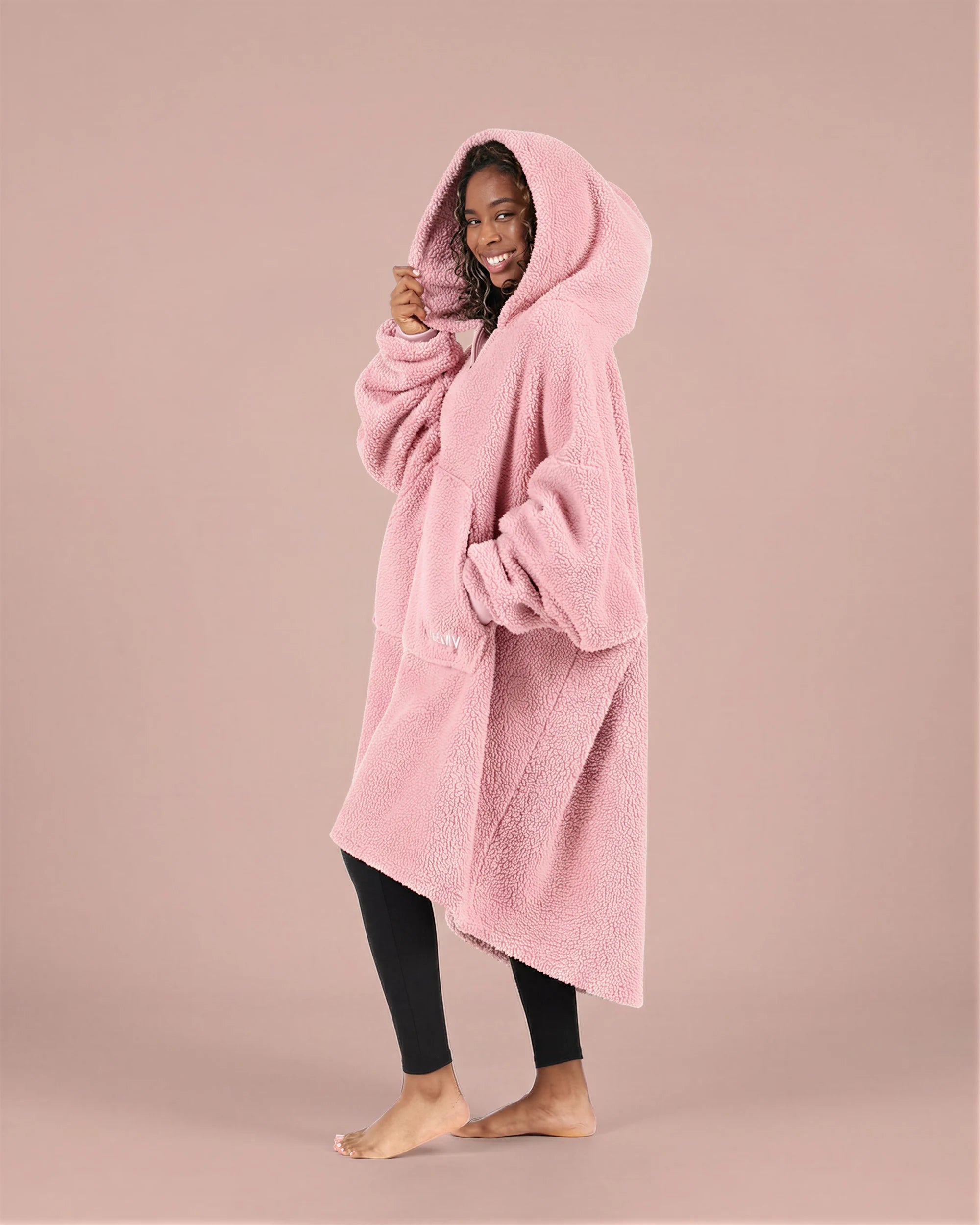 Side view of The Teddy Bear Quarter-Zip wearable blanket in blush highlighting relaxed drape, hood, and plush CloudSherpa™ texture