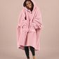 Front view of The Teddy Bear Quarter-Zip wearable blanket in blush with hands in pocket showing oversized sleeves and cozy fit