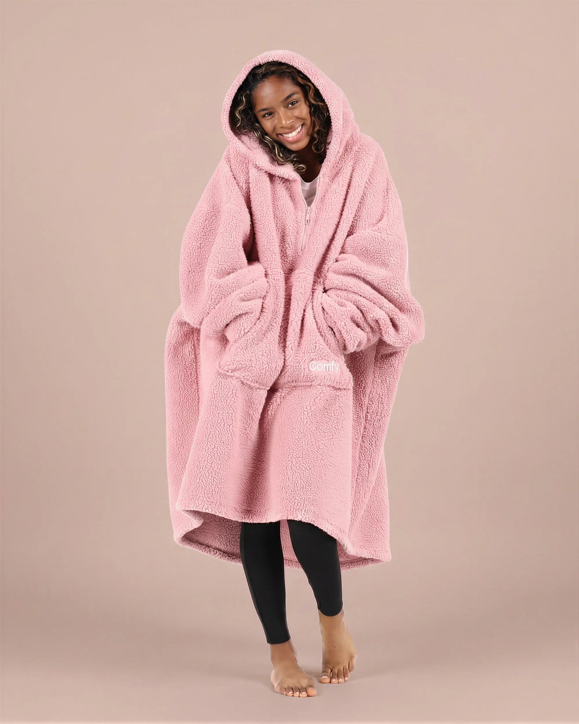 Front view of The Teddy Bear Quarter-Zip wearable blanket in blush with hands in pocket showing oversized sleeves and cozy fit