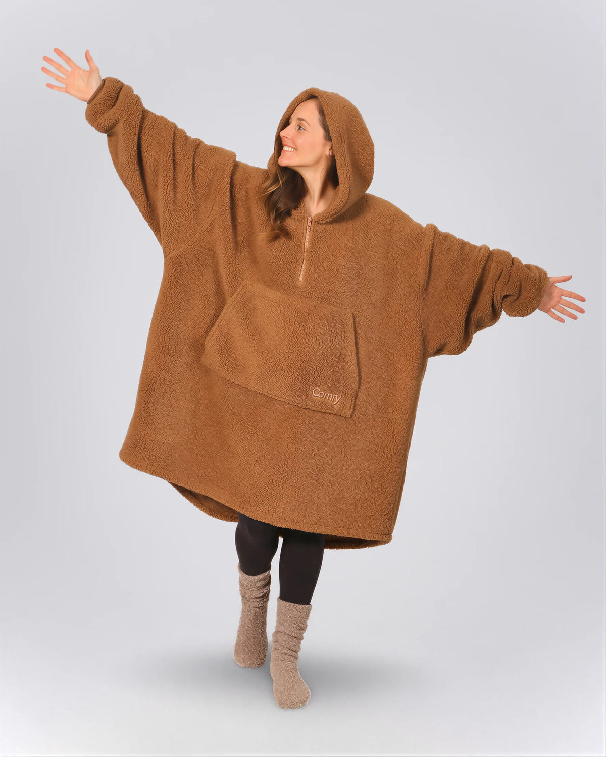 Front view of The Teddy Bear Quarter-Zip wearable blanket in camel showing oversized fit and all-over CloudSherpa™ fabric with hood up and arms extended