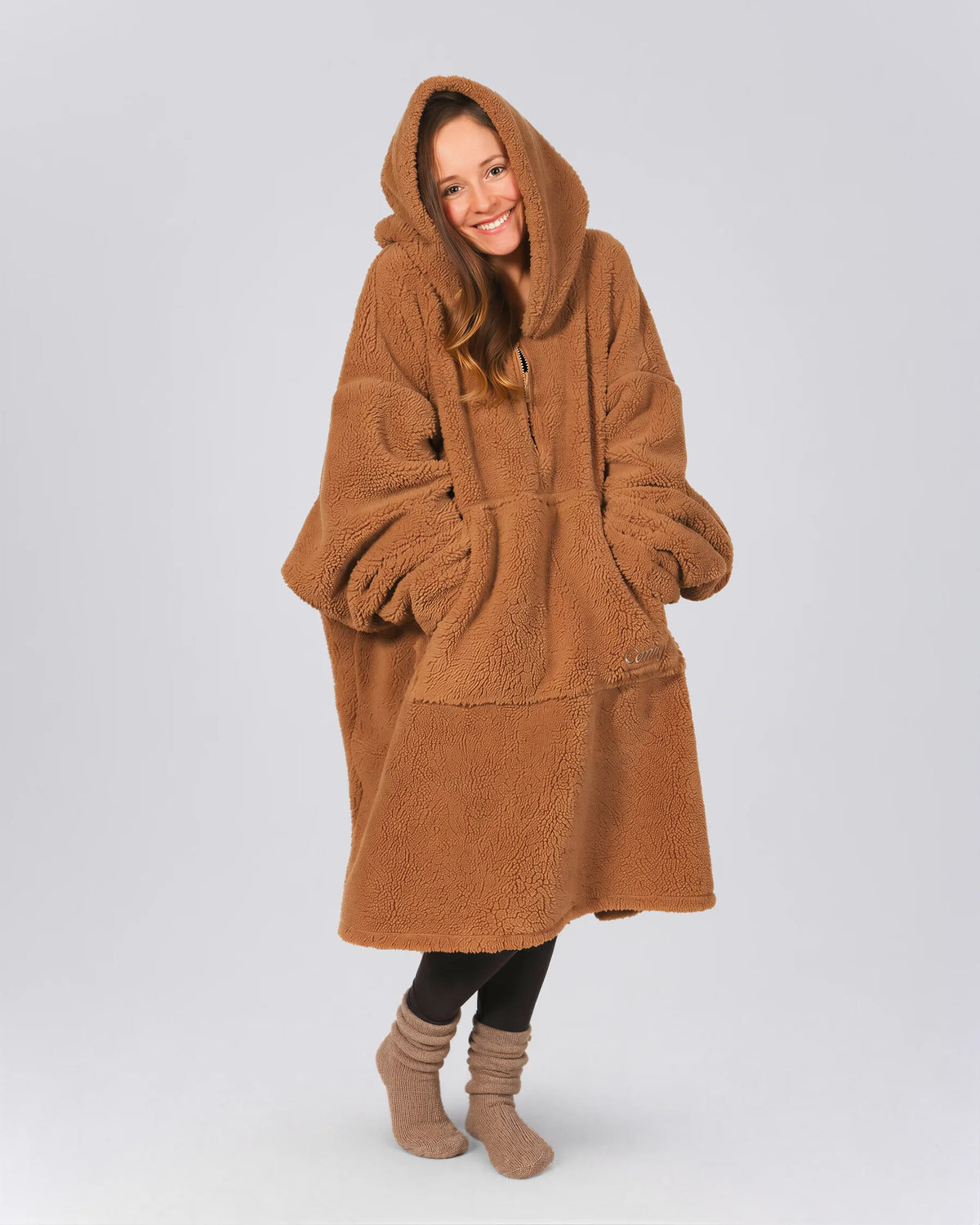 Front view of The Teddy Bear Quarter-Zip wearable blanket in camel showing relaxed oversized silhouette with hood up and hands tucked inside