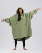Front view of The Teddy Bear Quarter-Zip wearable blanket in cucumber showing oversized fit and all-over CloudSherpa™ fabric with hood up and arms extended
