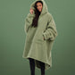 Three-quarter view of The Teddy Bear Quarter-Zip wearable blanket in cucumber highlighting relaxed drape, hood, and plush CloudSherpa™ texture