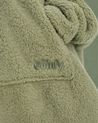 Close-up of The Teddy Bear Quarter-Zip wearable blanket in cucumber showing sleeve detail and embroidered logo on soft CloudSherpa™ fabric
