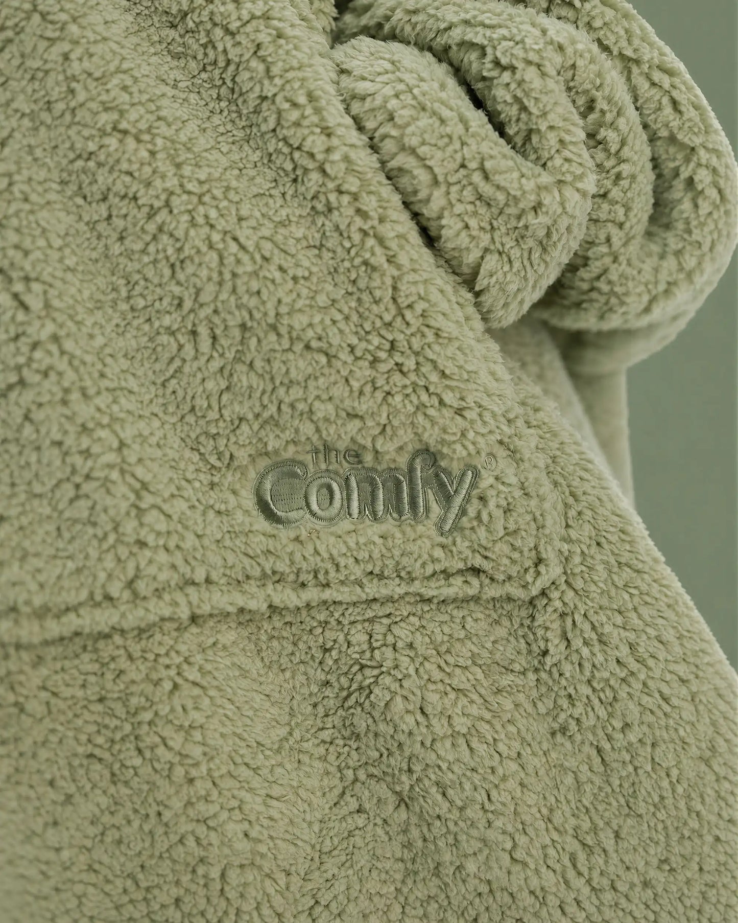 Close-up of The Teddy Bear Quarter-Zip wearable blanket in cucumber showing sleeve detail and embroidered logo on soft CloudSherpa™ fabric
