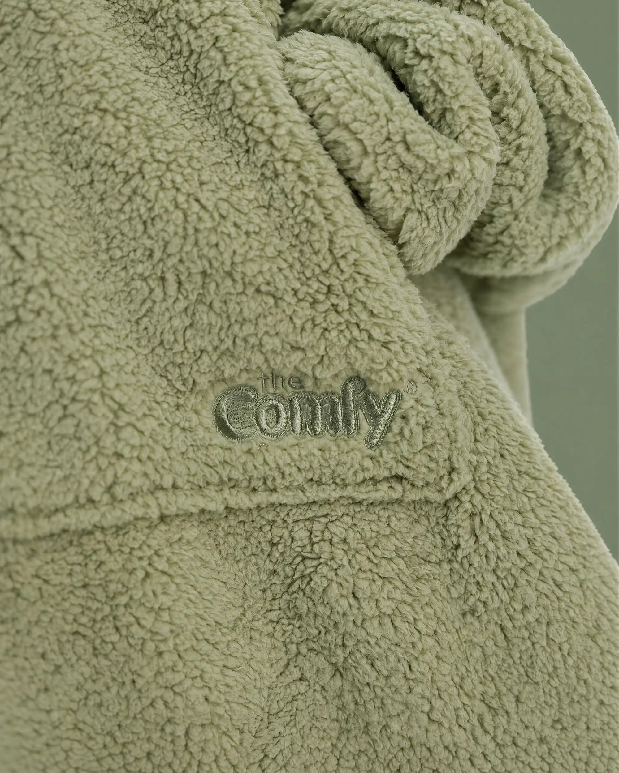 Close-up of The Teddy Bear Quarter-Zip wearable blanket in cucumber showing sleeve detail and embroidered logo on soft CloudSherpa™ fabric