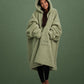Front view of The Teddy Bear Quarter-Zip wearable blanket in cucumber with model wrapped in oversized fit showing full coverage and cozy silhouette