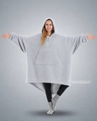 Front view of The Teddy Bear Quarter-Zip wearable blanket in light gray showing oversized fit and all-over CloudSherpa™ fabric with hood up and arms extended