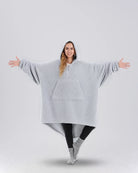 Front view of The Teddy Bear Quarter-Zip wearable blanket in light gray showing oversized fit and all-over CloudSherpa™ fabric with hood up and arms extended