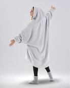 Back view of The Teddy Bear Quarter-Zip wearable blanket in light gray highlighting oversized drape and hooded silhouette