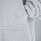 Close-up of The Teddy Bear Quarter-Zip wearable blanket in light gray showing embroidered logo and soft CloudSherpa™ texture