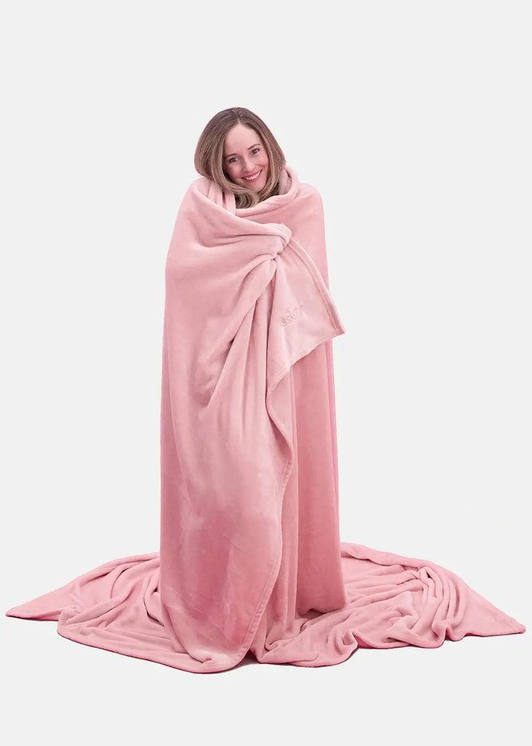 Woman wrapping herself in a pink The Comfy Dream Big Blanket