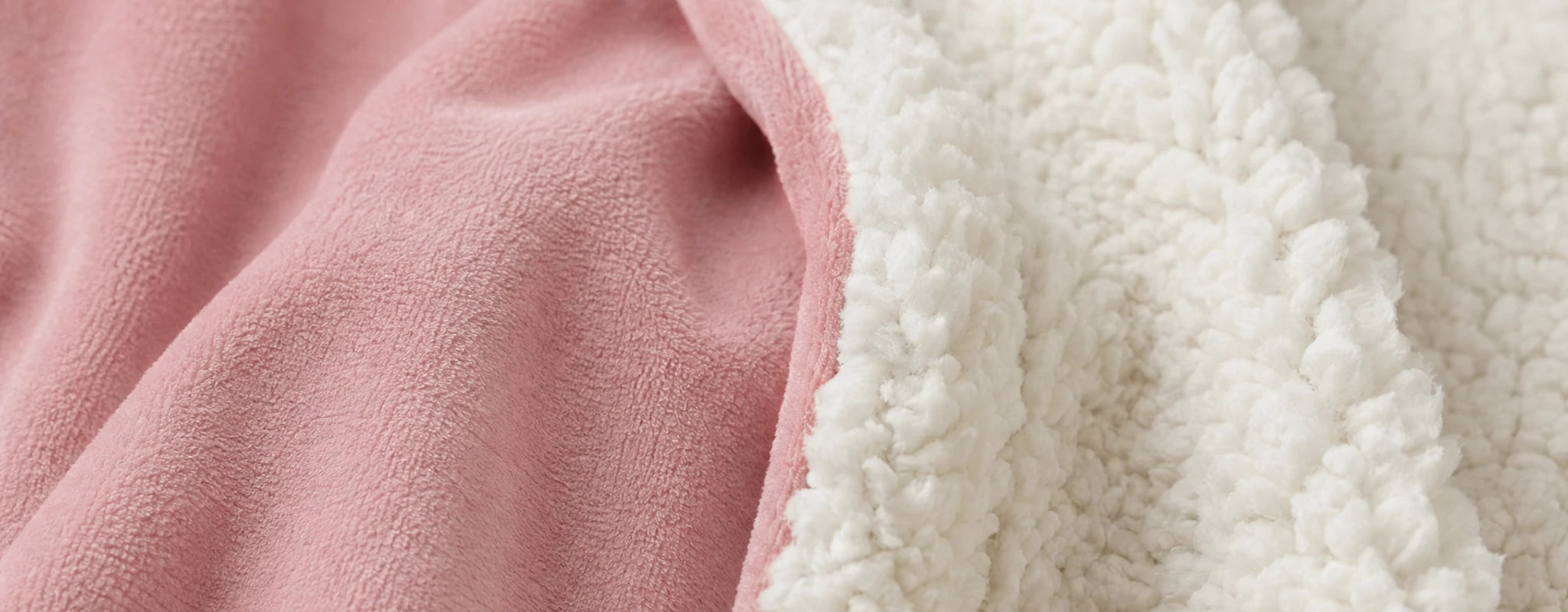 Close-up of blush Velveluxe fabric beside white CloudSherpa lining.