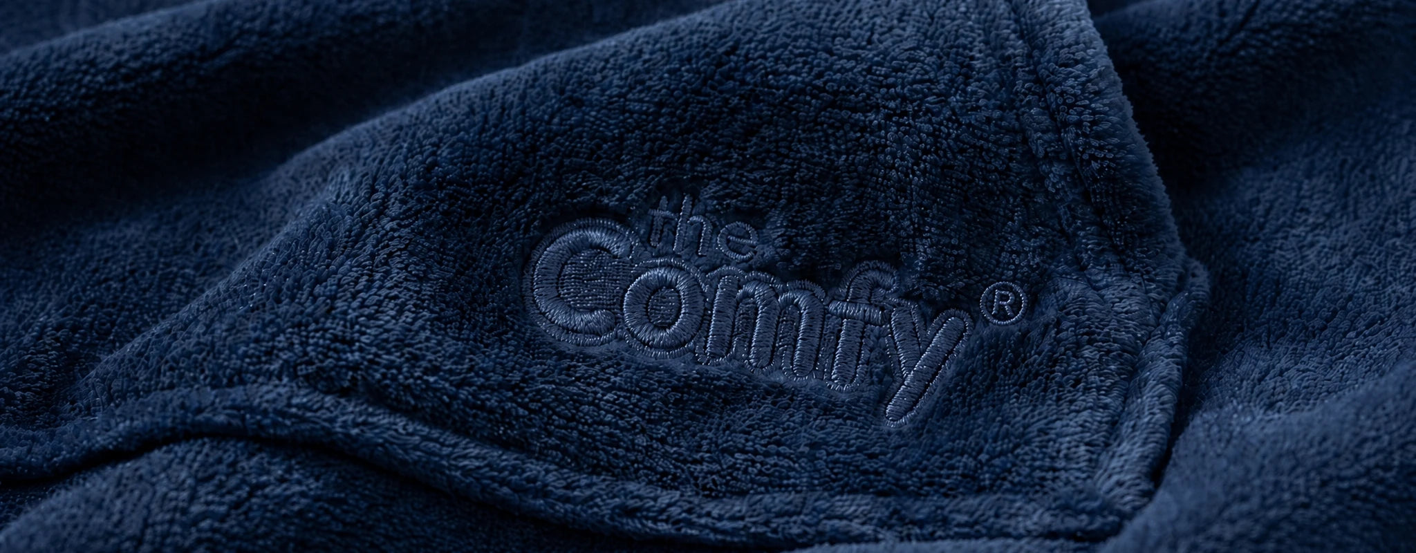 Close-up of navy DreamHaven™ fabric with The Comfy embroidery.