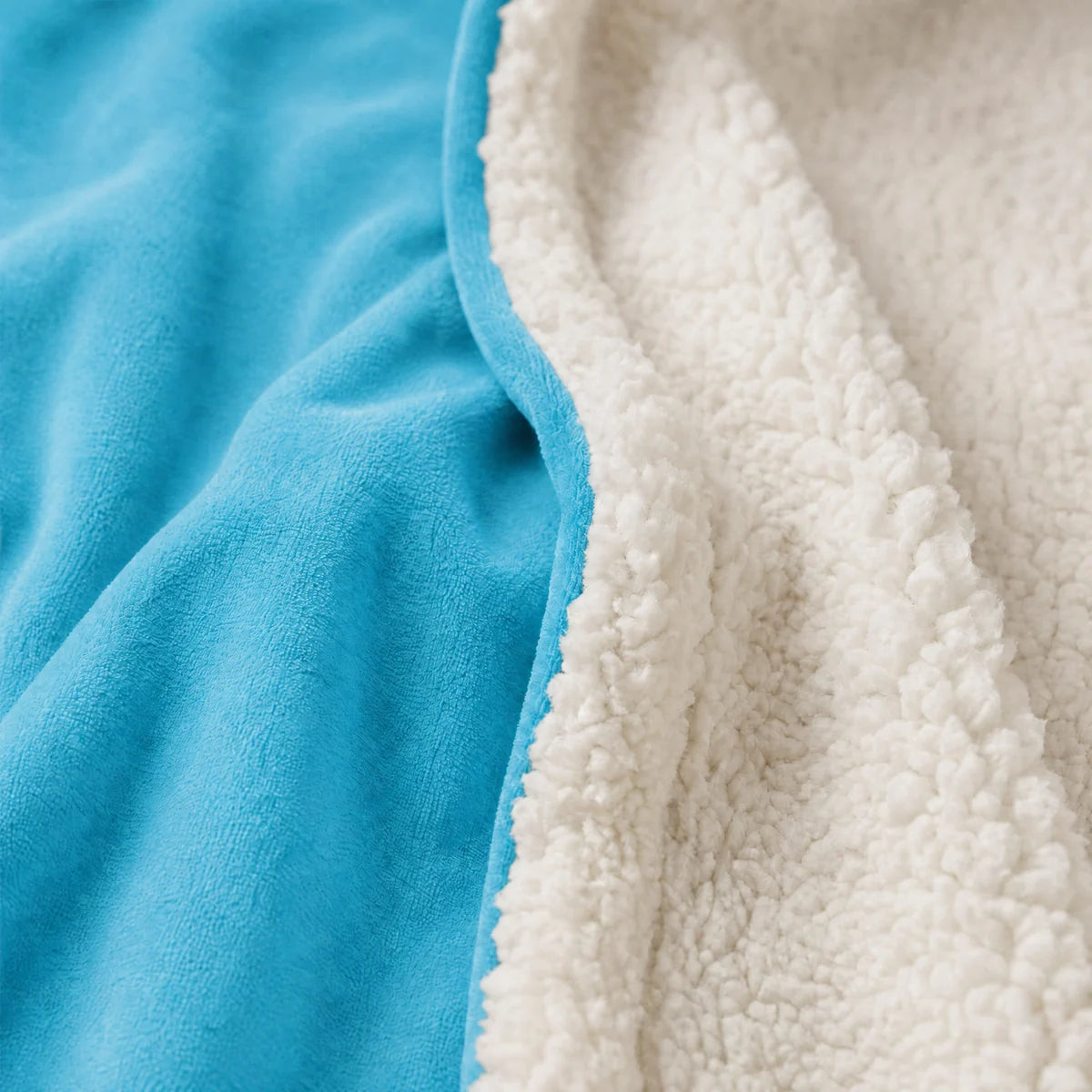 Close-up of neon aqua Velveluxe™ fabric beside white CloudSherpa™ lining.
